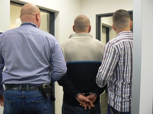 zatrzymany za rozbój prowadzony w kajdankach przez dwóch funkcjonariuszy Policji