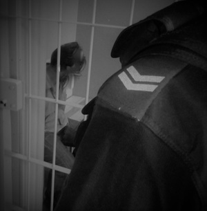 na zdjęciu widać zatrzymanego który siedzi w celi