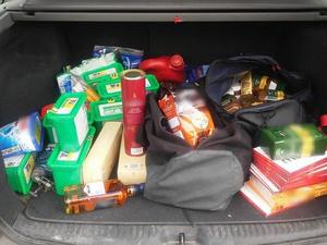 Chemia gospodarcza i inne artykuły spożywcze w siatkach włożone do bagażnika samochodu.