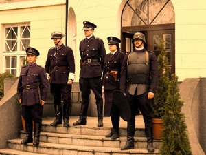 do zdjęcia pozuje pięć osób stojących na schodach w mundurach z czasów policji państwowej