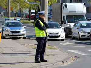 policjant w kamizelce odblaskowej stoi przy skrzyzowaniu