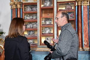 Kobieta i mężczyzna z aparatem fotograficznym  rozmawiają na tle eksponatów muzealnych