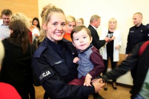 Policjantka trzyma na rękach małe dziecko