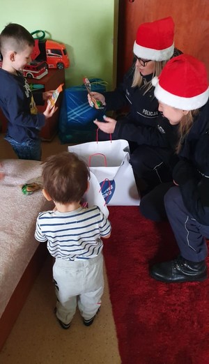 Policjanci z Piły z czapkami mikołajów w odwiedzinach u dzieci w szpitalu i ich domach