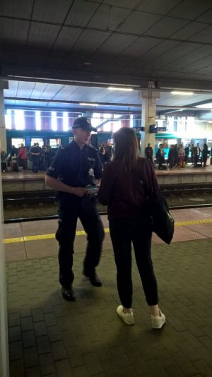 policjant rozmawia z kobieta na peronie pkp