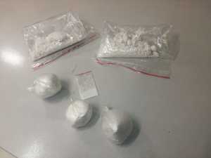 Narkotyki w postaci białego proszku zawinięte w pięć woreczków foliowych, leżących na stronie