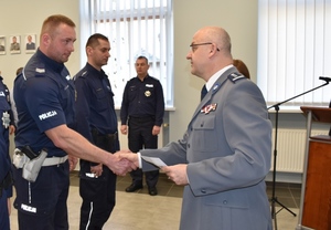 Komendant śremskiej policji w galowym mundurze gratuluje umundurowanego policjantowi