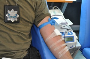 policjanci oddają krew siedząc na fotelach w krwiobusie