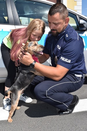 Policjant ze śremskiej drogówki wraz z uratowanym pieskiem i swoją kilkuletnią córką