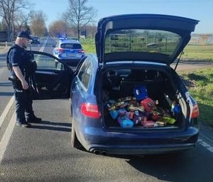 policjant przy aucie z towarem w bagażniku