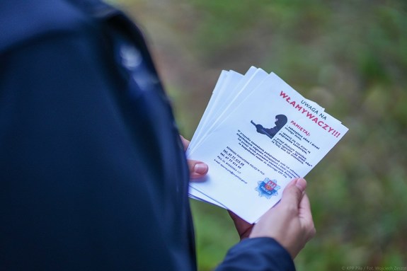 policjant z ulotkami dot. włamań