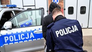 mężczyzna zakuwany w kajdanki przez policjanta