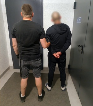 policjant z zatrzymanym; sprawca w sklepie