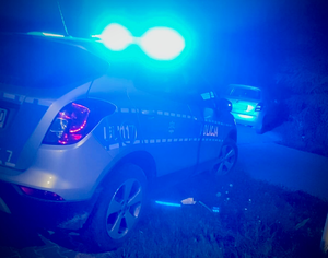 noc; radiowóz stojący za autem