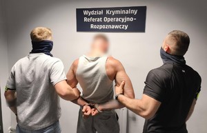 policjanci z zatrzymanymi, kajdanki