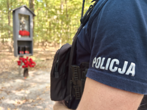 uszkodzona kapliczka, poli8cjant przy kapliczce
