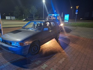 zatrzymany samochód oraz radiowozy, wieczór