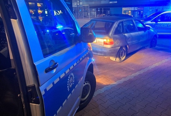 zatrzymany samochód oraz radiowozy, wieczór