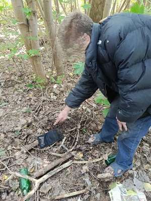 mężczyzna w lesie wskazuje na portfel