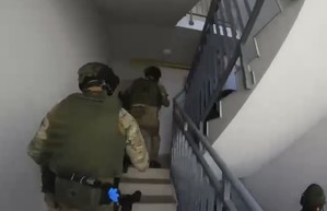 policjanci z zatrzymanym; zabezpieczone narkotyki, papierosy i pieniądze