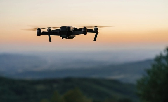 Lecący dron na tle krajobrazu