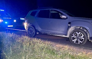 noc, samochód stoi na poboczu, za nim radiowóz