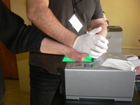 policjant ściąga odciski palców z ręki mężczyzny