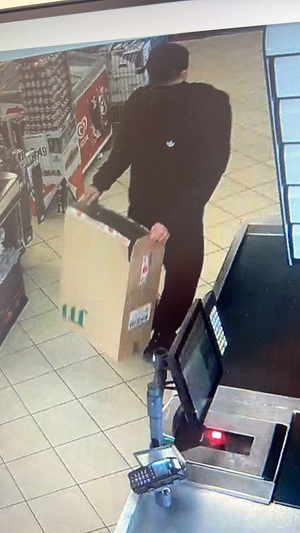 mężczyzna kradnie papierosy