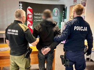 policjant i strażnik graniczny z zatrzymanym mężczyzną