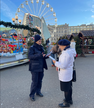 Policjantka rozdająca ulotki osobom starszym