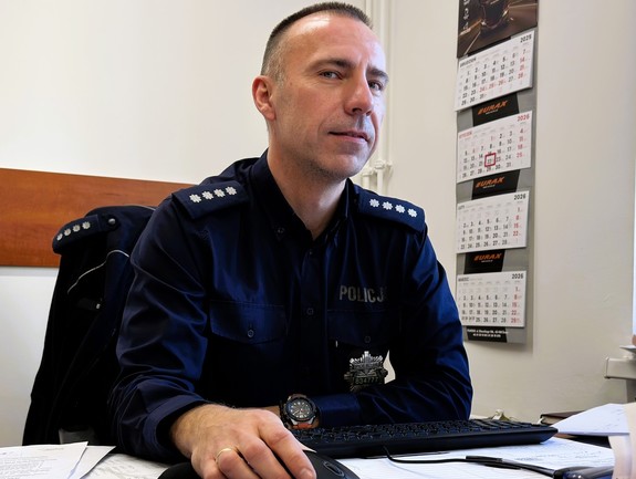 policjant siedzący przy biurku