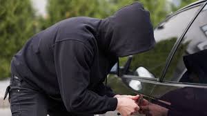 mężczyzna włamujący się do auta