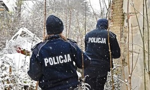 zima, policjanci idą przez ośnieżony teren