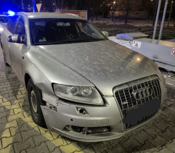 policjanci z zatrzymanym; samochód audi