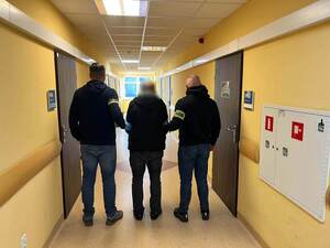 Zatrzymany mężczyzna prowadzony przez policjantów