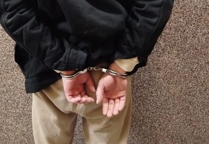 ręce zatrzymanego skute kajdankami