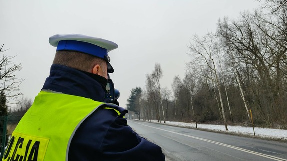 policjant mierzący prędkość przy drodze