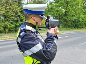 Policjant mierzy prędkość przy drodze