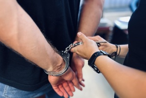 policjant zakuwa mężczyznę w kajdanki