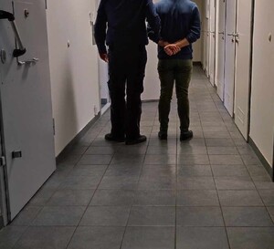 policjant z zatrzymanym mężczyzną (zdjęcie poglądowe)