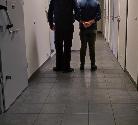 policjant z zatrzymanym mężczyzną (zdjęcie poglądowe)