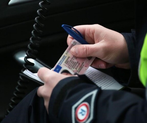 policjant wrd z dokumentami w rękach