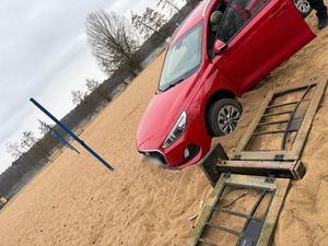 policjanci z zatrzymanym; auto na plaży