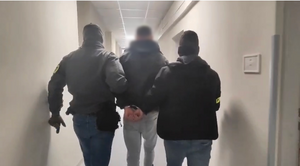 policjanci z zatrzymanym; auto na plaży