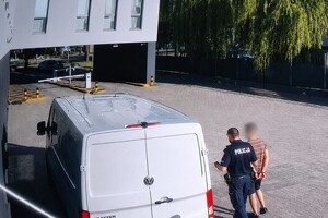 mężczyzna prowadzony przez policjanta