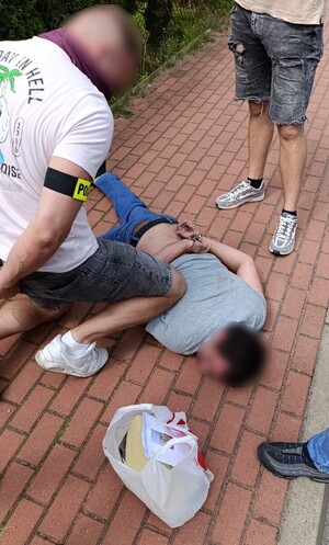 odzyskana gotówka i przedmioty; policjanci z zatrzymanym