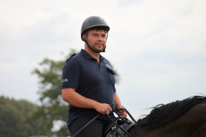 Nowy jeździec poznańskiego ogniwa konnego siedzi na wierzchowcu, na którym trenuje.
